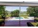 Enjoy a view from the balcony with a pool, green lawn and trees that meet the beautiful open water at 5671 Cypress Gardens Rd, Winter Haven, FL 33884
