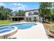 Beautiful backyard with an in-ground pool and spa, with the home's elevation in the background at 5671 Cypress Gardens Rd, Winter Haven, FL 33884