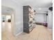 Open-concept hallway featuring ceramic tile flooring and unique stacked stone accent wall at 5671 Cypress Gardens Rd, Winter Haven, FL 33884