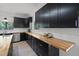 Bright kitchen featuring dark cabinets, stainless steel appliances, and butcher block countertops at 5671 Cypress Gardens Rd, Winter Haven, FL 33884