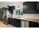 Updated kitchen with stainless steel appliances, wood countertops and dark cabinetry at 5671 Cypress Gardens Rd, Winter Haven, FL 33884