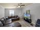 Living room with wood floors and a large leather sofa. TV, ceiling fan and two windows included at 5671 Cypress Gardens Rd, Winter Haven, FL 33884