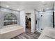 Luxurious bathroom with a soaking tub, glass-enclosed shower, stylish fixtures, and contemporary design at 5671 Cypress Gardens Rd, Winter Haven, FL 33884