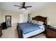 Spacious main bedroom featuring a large bed, tile floors, ceiling fan, and adjoining closet and bathroom at 5671 Cypress Gardens Rd, Winter Haven, FL 33884
