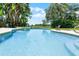 Backyard in-ground pool with an outdoor chair and a lush landscaped yard at 5671 Cypress Gardens Rd, Winter Haven, FL 33884