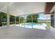 Covered patio with a view of the pool and landscaped backyard with waterfront view at 5671 Cypress Gardens Rd, Winter Haven, FL 33884