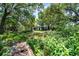 Secluded property surrounded by lush greenery and a wooden bridge leading to the tranquil house at 5671 Cypress Gardens Rd, Winter Haven, FL 33884