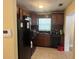 Well-lit kitchen features a black refrigerator, dark cabinets, and an updated sink at 625 E Jackson Ave, Mount Dora, FL 32757