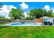 Backyard featuring a sparkling pool, outdoor dining area, well-manicured lawn, and wooden privacy fence at 7616 Simms Ave, Orlando, FL 32812
