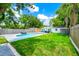 Backyard featuring a swimming pool, a lush lawn, privacy fence and mature landscaping at 7616 Simms Ave, Orlando, FL 32812
