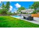 Backyard with pool, patio seating, large lawn, and privacy fence offering a relaxing outdoor space at 7616 Simms Ave, Orlando, FL 32812