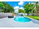 Inviting backyard pool area with patio furniture and a well-maintained lawn and privacy fence at 7616 Simms Ave, Orlando, FL 32812