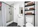 Well-lit bathroom features a walk-in shower, modern vanity, and stylish shelving unit at 7616 Simms Ave, Orlando, FL 32812