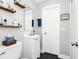 Bathroom with floating shelves, modern vanity and novelty wall art for an added touch of personality at 7616 Simms Ave, Orlando, FL 32812