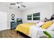 Bedroom features a ceiling fan, natural light, wood-look floors, and comfortable bedding at 7616 Simms Ave, Orlando, FL 32812