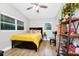 Bedroom features natural light, ceiling fan, wood-look floors, and a shelf for storage and display at 7616 Simms Ave, Orlando, FL 32812