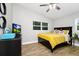 Cozy bedroom with yellow accents, TV, dresser, and wood-look flooring at 7616 Simms Ave, Orlando, FL 32812