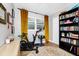 Bedroom with fitness equipment, including exercise bike and weights, plus bookshelf, wood floor, and natural light at 7616 Simms Ave, Orlando, FL 32812