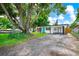 Charming single-story home featuring a modern design, a well-manicured lawn, and large shade tree at 7616 Simms Ave, Orlando, FL 32812
