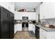 Modern kitchen features white cabinets, stainless steel appliances, granite countertops, and wood-look flooring at 7616 Simms Ave, Orlando, FL 32812