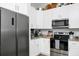 Well-lit kitchen boasts white cabinets, stainless steel appliances, and granite countertops at 7616 Simms Ave, Orlando, FL 32812