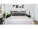 Comfortable bedroom features a bed with gray bedding, bedside tables, and decorative mirrors at 7616 Simms Ave, Orlando, FL 32812