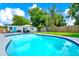 Backyard pool with patio furniture, lush landscaping, privacy fence, shed and bright blue skies at 7616 Simms Ave, Orlando, FL 32812