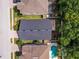 Aerial view of a home with a dark roof, surrounded by trees and neighboring houses with a pool at 879 Nonastone Run, Casselberry, FL 32707