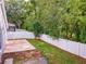 Grassy backyard surrounded by privacy fence and mature trees, with concrete patio at 879 Nonastone Run, Casselberry, FL 32707
