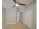 This is an empty bedroom with a ceiling fan, tile floors, and access to a closet at 879 Nonastone Run, Casselberry, FL 32707