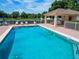 Refreshing community pool with lounge chairs, cabana, and view of the serene pond at 879 Nonastone Run, Casselberry, FL 32707