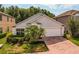 Charming single-story home with a well-maintained lawn, mature palm trees, and an attached two-car garage at 879 Nonastone Run, Casselberry, FL 32707