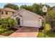 Charming single-story home with a well-maintained lawn, mature palm trees, and an attached two-car garage at 879 Nonastone Run, Casselberry, FL 32707