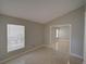 An empty living room with tile floors, large window for natural light, and view to adjacent room at 879 Nonastone Run, Casselberry, FL 32707