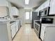Modern kitchen with stainless steel appliances, tile floors, and white cabinetry at 936 Birmingham Ct # 200, Lake Mary, FL 32746