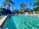 Community pool with clear water, lounge chairs, and tropical trees providing a relaxing outdoor space at 936 Birmingham Ct # 200, Lake Mary, FL 32746