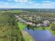 An aerial view showcases the neighborhood's proximity to a picturesque lake and green fields at 9780 Cypress Pine St, Orlando, FL 32827