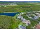An aerial perspective of homes backing onto a lake, near a sprawling green space at 9780 Cypress Pine St, Orlando, FL 32827