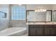 Bright bathroom features a double vanity, soaking tub, and large window at 9780 Cypress Pine St, Orlando, FL 32827