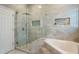 Modern bathroom with glass shower, soaking tub, and stylish gray tiling at 9780 Cypress Pine St, Orlando, FL 32827
