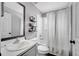 This bathroom features a shower-tub combo, framed mirror, black shelving, and a single sink vanity at 9821 8Th Ave, Orlando, FL 32824