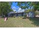 Backyard view of home with enclosed back patio and lush lawn with scattered trees, offering a serene outdoor space at 985 N Village Dr, Deltona, FL 32725