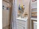Bathroom features a shower with decorative tiling and a sink with storage underneath, and shelving for toiletries at 985 N Village Dr, Deltona, FL 32725