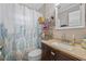 A well-lit bathroom features a granite countertop, a vanity cabinet and a shower-tub combination for convenience at 985 N Village Dr, Deltona, FL 32725