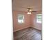 Cozy bedroom with ceiling fan, wood-look flooring, and two windows at 985 N Village Dr, Deltona, FL 32725