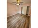 A charming bedroom featuring wood-look flooring, a ceiling fan, and a closet for convenient storage at 985 N Village Dr, Deltona, FL 32725