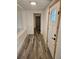 Bright hallway with wood-look floors leads to the front door and other rooms at 985 N Village Dr, Deltona, FL 32725