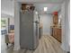 A view of kitchen from another room showcasing wood cabinets, stainless steel appliances, and durable wood-look flooring at 985 N Village Dr, Deltona, FL 32725