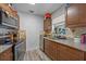A cozy kitchen featuring wood cabinets, speckled granite countertops, and stainless steel appliances, perfect for home cooking at 985 N Village Dr, Deltona, FL 32725