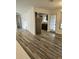 Open living room with wood-look floors leading to kitchen and other rooms at 985 N Village Dr, Deltona, FL 32725